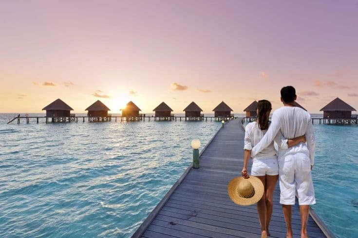 Couple on dock overlooking overwater bungalows